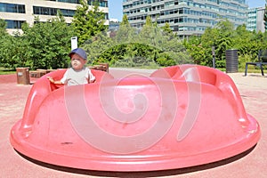 Toddler boy playing on playground - marry go round