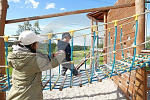 Toddler boy playing on playground - net bridge