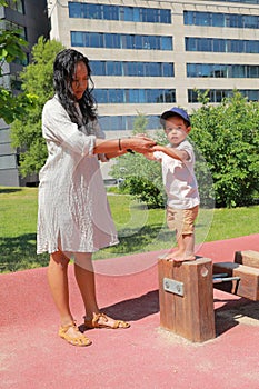 Toddler boy playing on playground - standing on edge of unstable wooden bridge