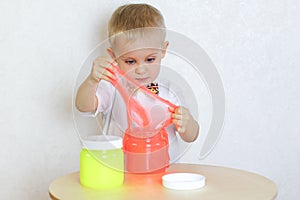 A toddler boy playing with slime, sensory play and developing fine motor skills activity