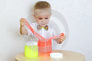 A toddler boy playing with slime, sensory play and developing fine motor skills activity