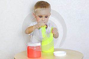 A toddler boy playing with slime, sensory play and developing fine motor skills activity