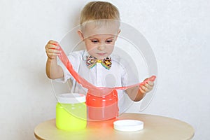 A toddler boy playing with slime, sensory play and developing fine motor skills activity