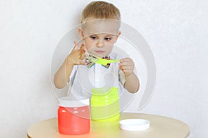 A toddler boy playing with slime, sensory play and developing fine motor skills activity