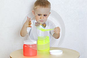 A toddler boy playing with slime, sensory play and developing fine motor skills activity