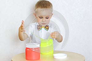 A toddler boy playing with slime, sensory play and developing fine motor skills activity