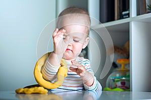 Toddler boy playing yellow plasticine Play-Doh in playroom close-up and copy space