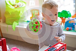 Toddler boy plays with educational toys in the children`s room. The study of colors and the development of tactility. Child one