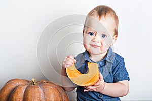 Toddler boy with pumpkin close-up. First baby food, autumn harvest..