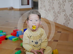 Toddler boy put a toy in his mouth. Child safety concept, dangerous child play.