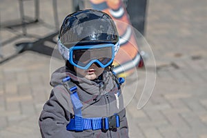 Toddler Boy Ready to Ski with all Safety Gear. Helmet & Harness.