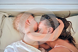 Toddler boy sleeping on pillow with mother