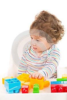 Toddler boy with toys looking away