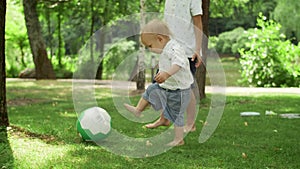 Toddler and brother playing with ball. Parents spending time with children