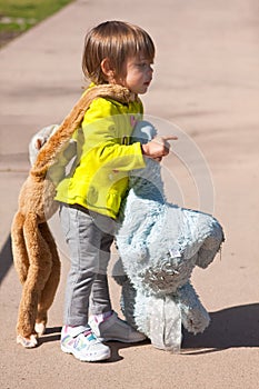 Toddler carrying stuffed animals