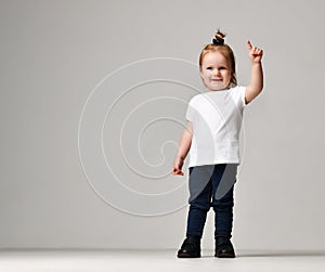 Toddler child baby girl kid standing in white free text space t-shirt pointing finger up