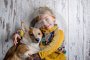 Toddler child and dog, boy and puppy playing together at home