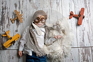 Toddler child and dog, boy and puppy playing together at home