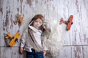 Toddler child and dog, boy and puppy playing together at home