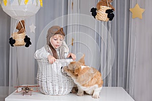 Toddler child and dog, boy and puppy playing together at home