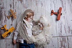 Toddler child and dog, boy and puppy playing together at home