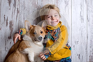 Toddler child and dog, boy and puppy playing together at home