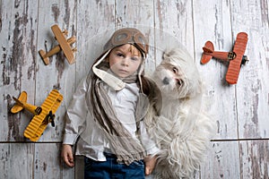 Toddler child and dog, boy and puppy playing together at home