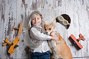 Toddler child and dog, boy and puppy playing together at home