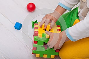 Toddler or child is playing with plastic shape sorter.