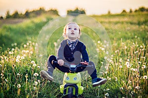 Toddler child in a summer dandelion field feels free and happy