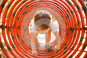 Toddler Climbing through Rings at the Playground