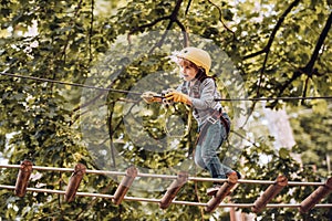 Toddler climbing in a rope playground structure. Children fun. Child concept. Safe Climbing extreme sport with helmet