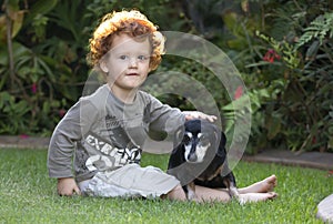 Un nino a el perro en el jardín 