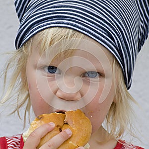 Toddler eating bread roll