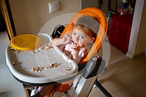 toddler eating dirty in the highchair at home