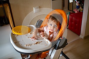 toddler eating dirty in the highchair at home
