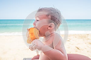 Toddler Eating a Freshly Sliced Mango on the Beach