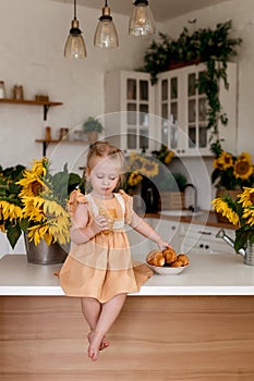 Toddler eats croissants. Cute little girl having breakfast in the kitchen