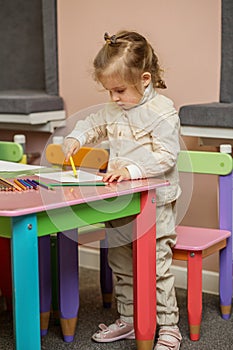 Toddler Engrossed in Drawing at Colorful Table