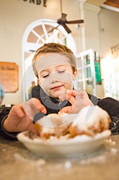 Toddler Enjoying Beignets at Cafe Du Monde photo