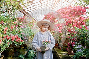 Toddler with flower basket. girl holding pink flowers