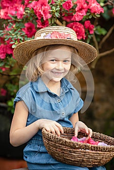 Toddler with flower basket. girl holding pink flowers