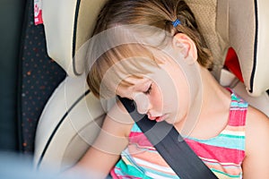 Toddler girl asleep in a car