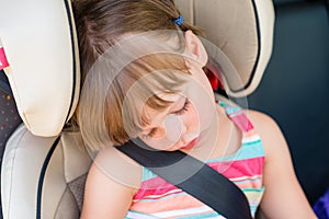 Toddler girl asleep in a car