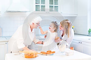 Toddler girl baking apple pie with her grandmothers