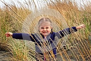 Toddler girl in beach grass