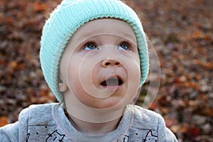 Toddler girl in blue hat staring at the sky