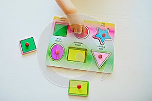 Toddler girl or boy doing wooden puzzle