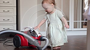 Toddler girl brings vacuum cleaner to tidy up spacious room