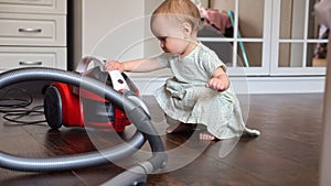 Toddler girl brings vacuum cleaner to tidy up spacious room